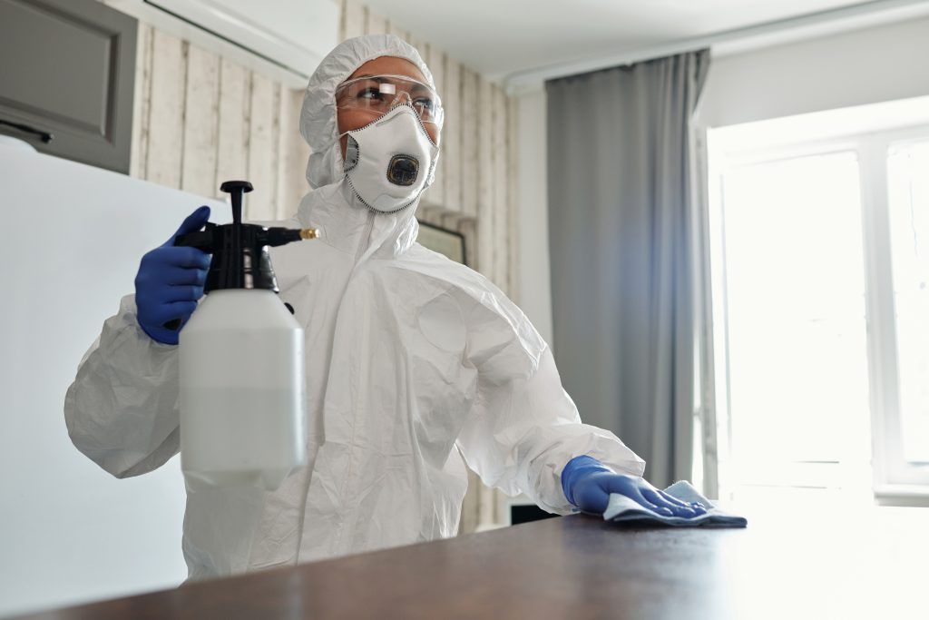 An image of a cleaner performing COVID deep cleaning to a work surface.